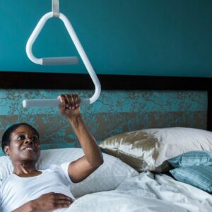 Woman using the SuperTrapeze and the e2 Trapeze Handle to sit up in bed