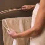 A woman grabbing the 24in Invisia Towel bar for support.