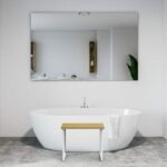 Invisia Shower Bench in front of a freestanding bathtub