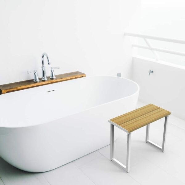 Invisia Shower Bench in front of a freestanding bath tub