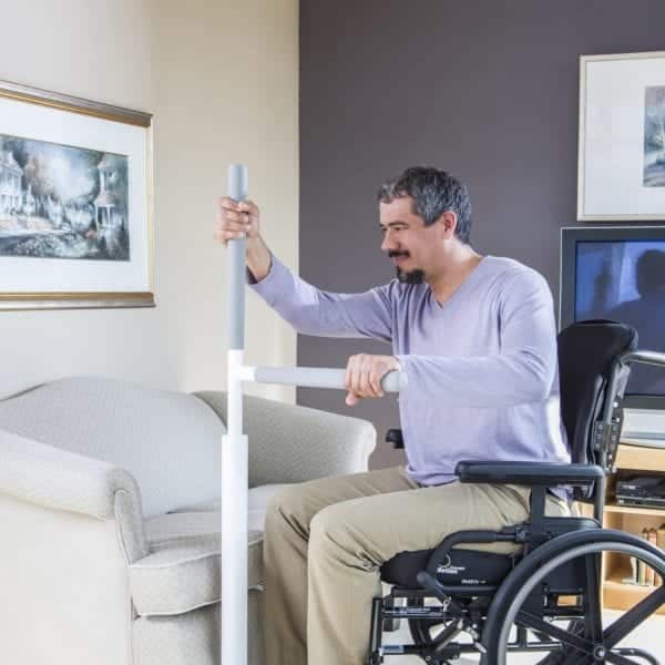 Man transferring from a wheelchair to a living room chair