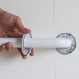 Photo of a person's hand installing the flange cover on a grab bar that has 9-hole flanges.