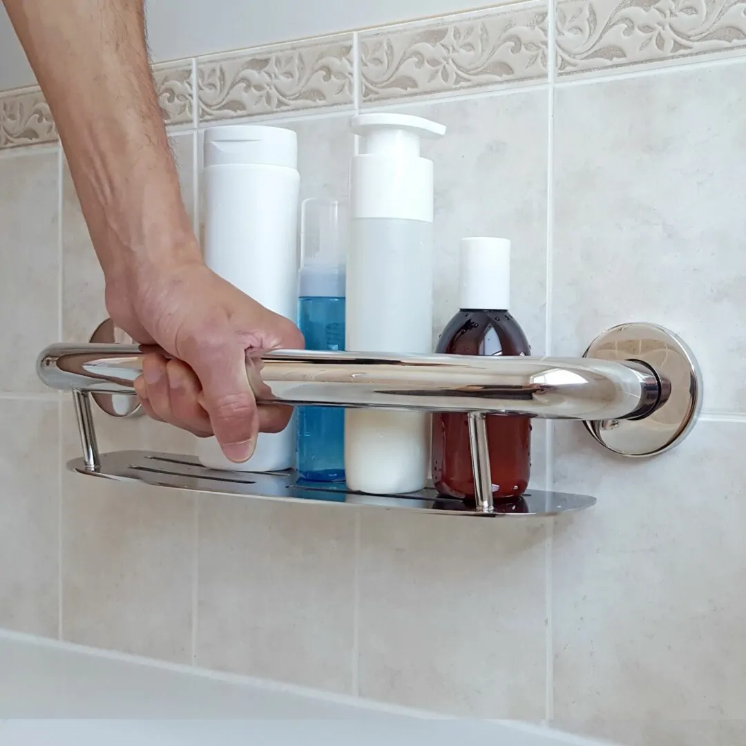 Plus Series Shampoo Shelf on a tiled wall with a hand holding it for support